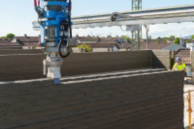 3D printer in the process of printing a concrete wall.