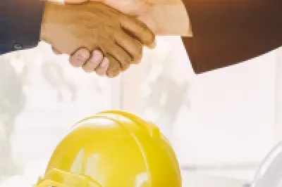 Two people wearing shirts shaking hands.