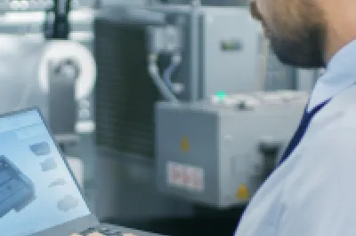 Engineer viewing a 3D CAD model on a laptop.