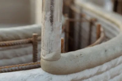 Close-up of a 3D-printed concrete wall with visible reinforcement bars.