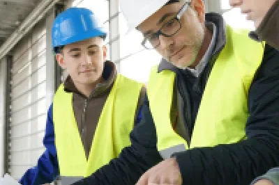 A group of engineers reviewing building plans on a construction site.