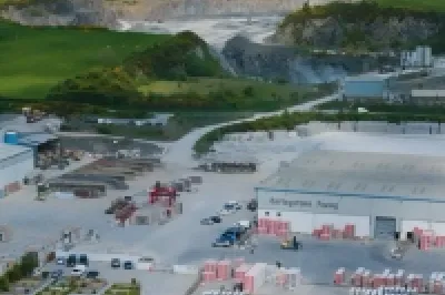 Aerial view of an industrial site with excavation areas surrounded by green countryside.