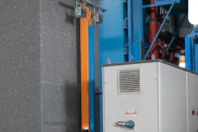 Industrial facility with large insulated panels and blue machinery, worker in safety vest visible, KORE Insulation logo.
