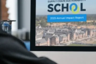 A man sitting on his desk on a computer and on the comuter screen 