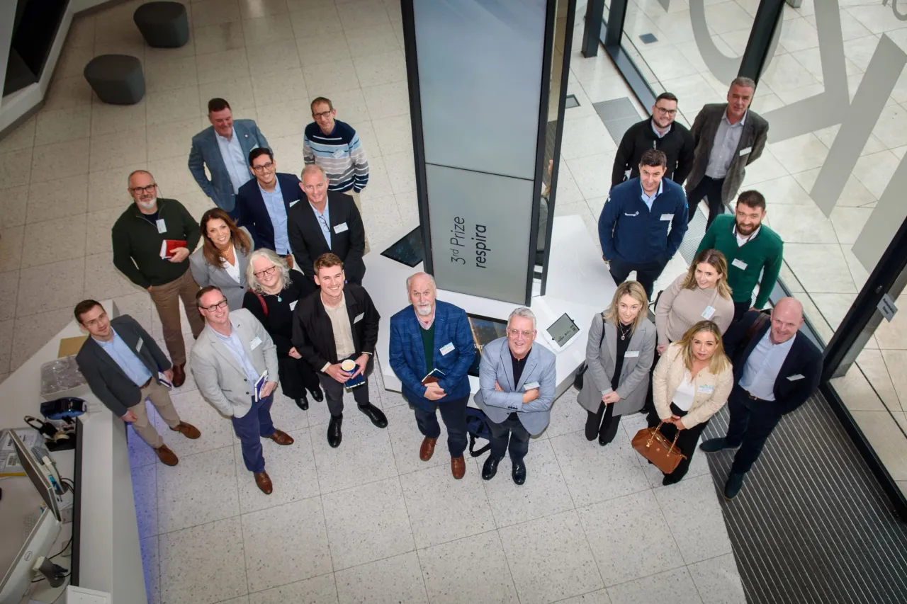 Group of people gathered in a modern building lobby, viewed from above.