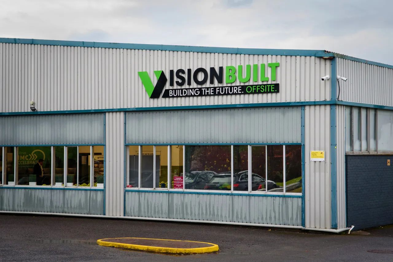 Vision Built Industries building with green signage on a gray industrial structure.