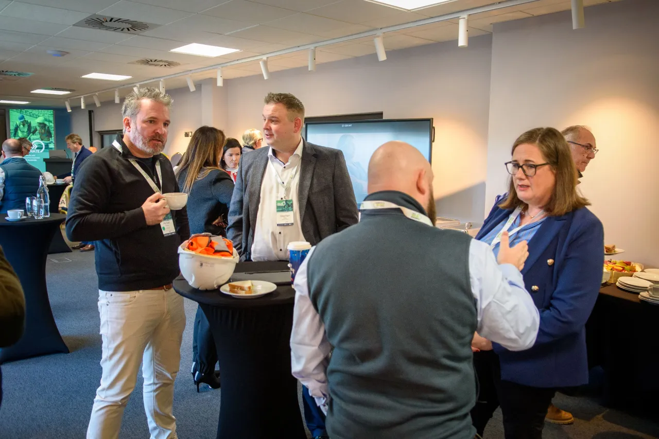 A small group of people standing in conversation at a professional networking event.