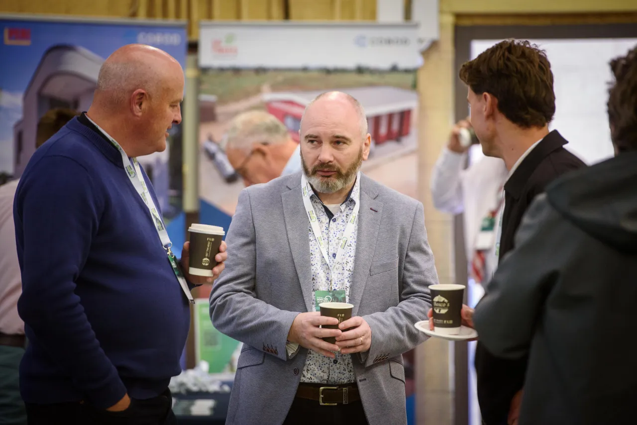 Three business professionals having a conversation at a networking event.