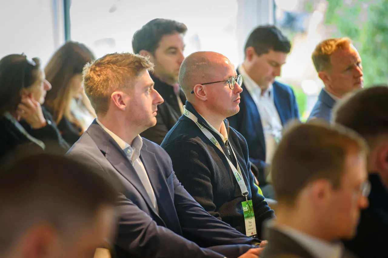 Business professionals attentively listening at a conference or meeting.