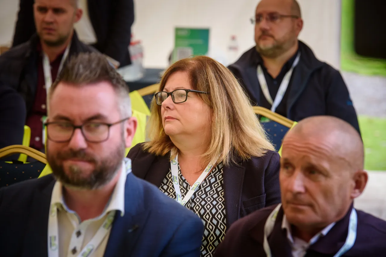 Attendees at a professional event, with several people visible in the audience.