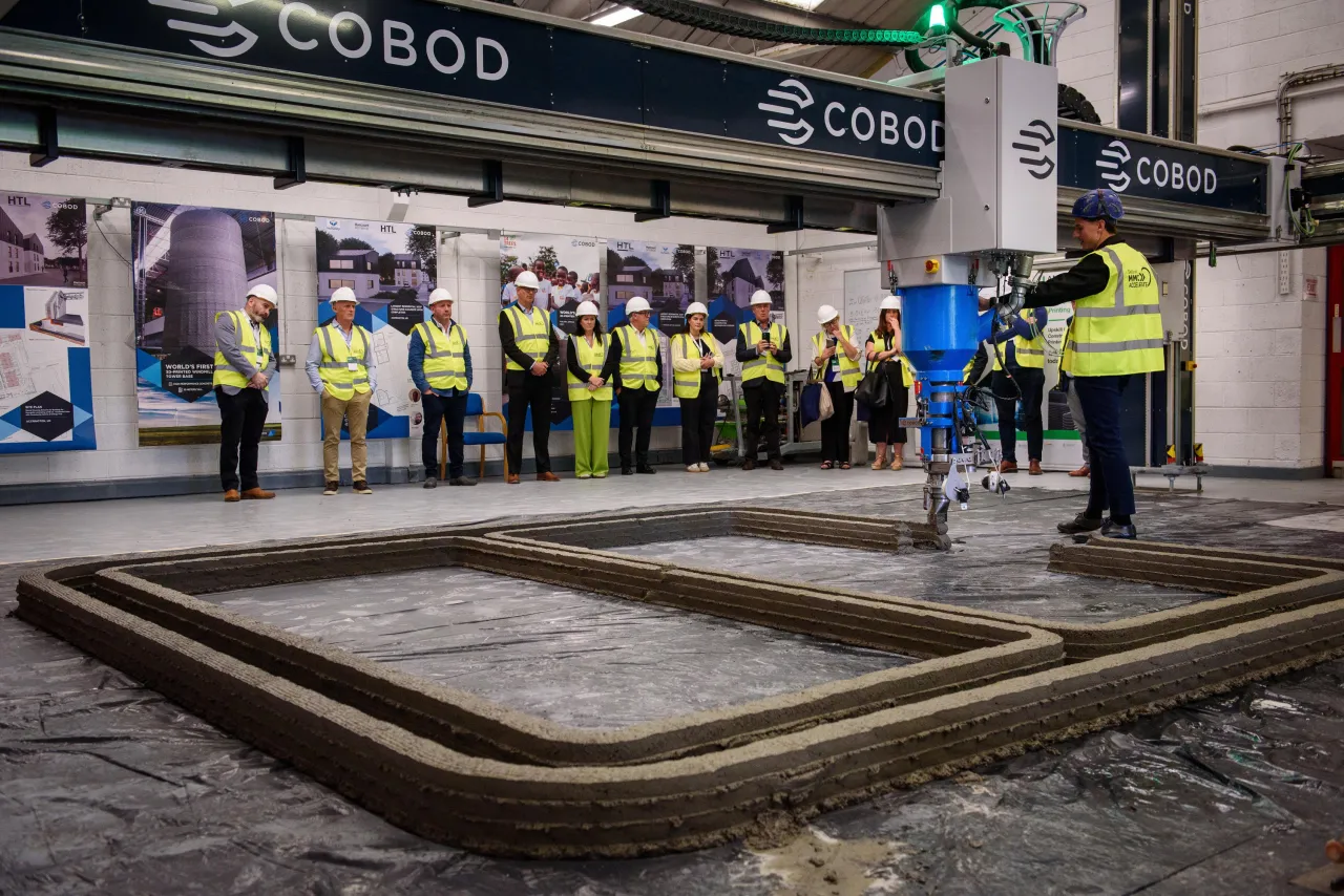 A crowd of people in safety vests gathered in what appears to be a train or subway station.