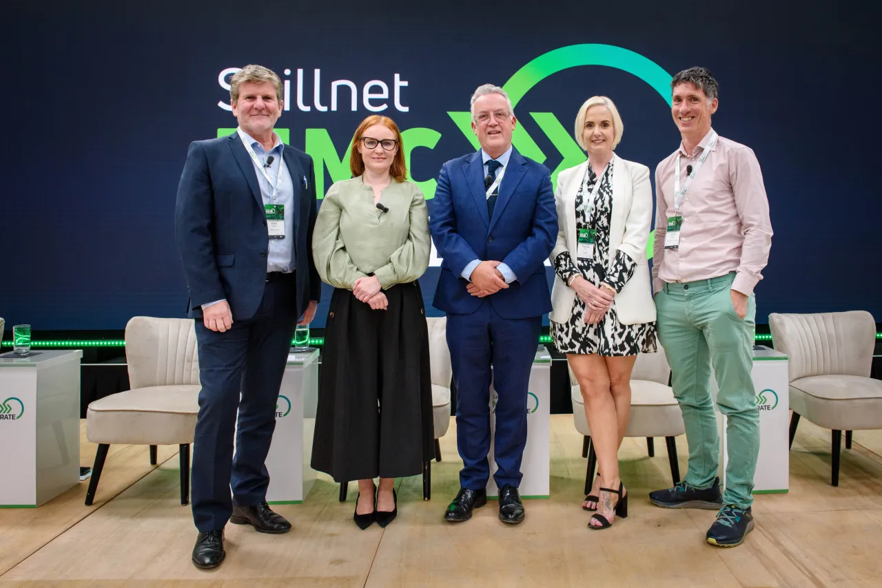 Five business professionals standing together at an event with a Skillnet logo backdrop.
