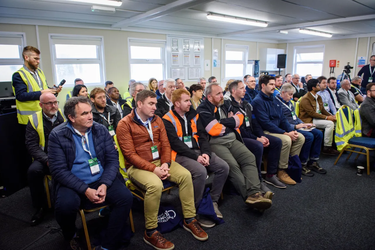 A group of people seated in rows at what appears to be a workplace meeting or safety briefing.