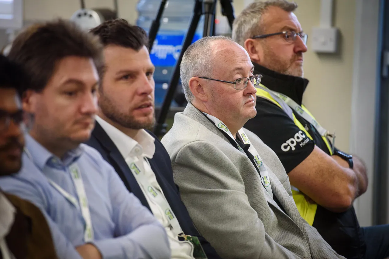 Audience members listening attentively at a professional conference or meeting.