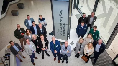 Group of people standing indoors, looking up towards the camera.