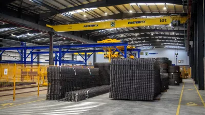 Stacks of welded steel frames in a manufacturing facility.
