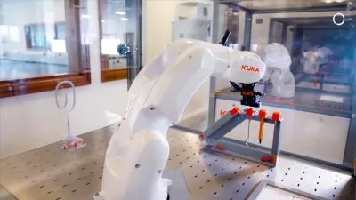 A white robotic arm in a modern engineering lab. 