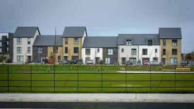 A row of modern terraced houses of different colours and sizes.