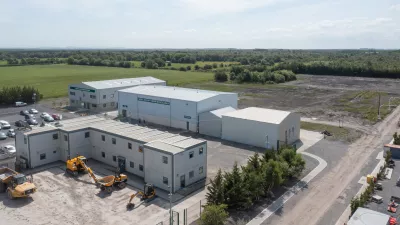 Modern white buildings with construction equipment outside that make up the National Training Campus.