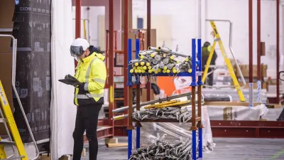 Workers in protective gear performing installation tasks inside an industrial facility