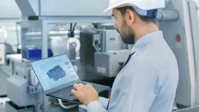 Engineer viewing a 3D CAD model on a laptop.