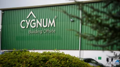 A green building with Cygnum logo, partially visible behind trees and bushes.