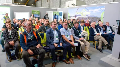ChatGPT said: Audience seated at an indoor event listening to a presentation, with banners for Thermohouse and Skillnet MMC Accelerate visible in the background.