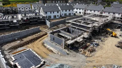 “Aerial view of a residential construction site with houses and concrete structures under development.