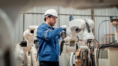 Person in blue jacket observing dairy cows in a farming facility.