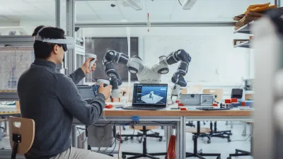 Person wearing VR headset interacting with robotic arm in a laboratory setting.