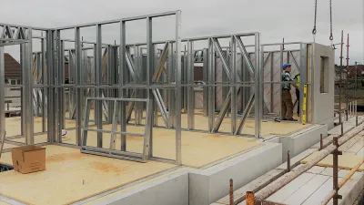 Steel frame structure on a concrete foundation at a construction site.
