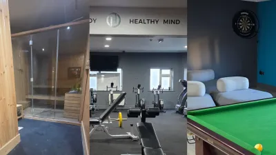 Indoor fitness center with exercise machines, dumbbells, and a pool table in a well-lit space.