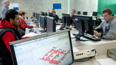 Several individuals working at computer desks in an office environment.