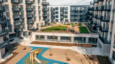 Modern residential apartment complex courtyard with a colorful children's playground below.