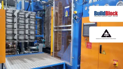 Industrial manufacturing machine in blue and orange with BuildBlock logo in upper right corner.