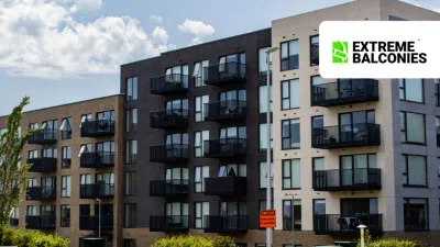 Modern multi-story apartment building with dark balconies under a blue sky, Extreme Balconies logo.
