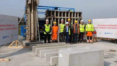Group of construction workers and officials posing at a concrete bridge foundation ceremony.