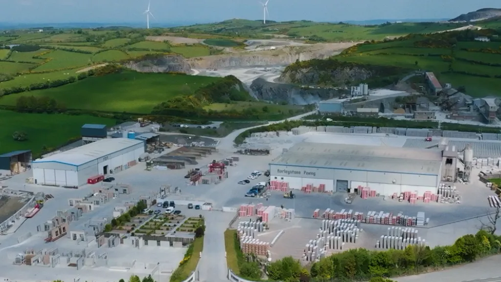 Aerial view of an industrial site with excavation areas surrounded by green countryside.
