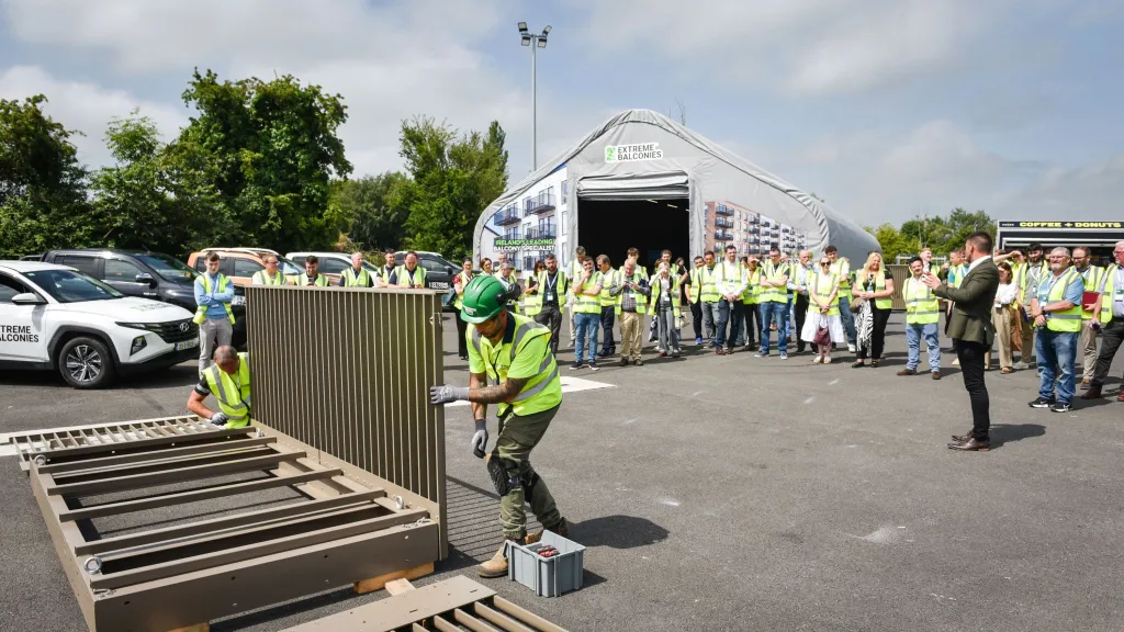 Workers in safety vests and hard hats gathered outdoors at an industrial facility during a demonstration.