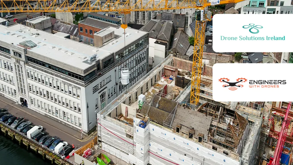 Aerial view of an active urban construction site with cranes, alongside a historic building.