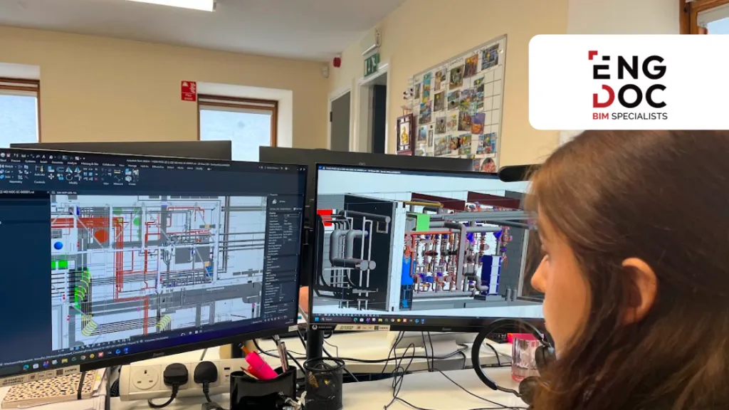 Woman working at a dual-monitor workstation displaying technical CAD drawings.