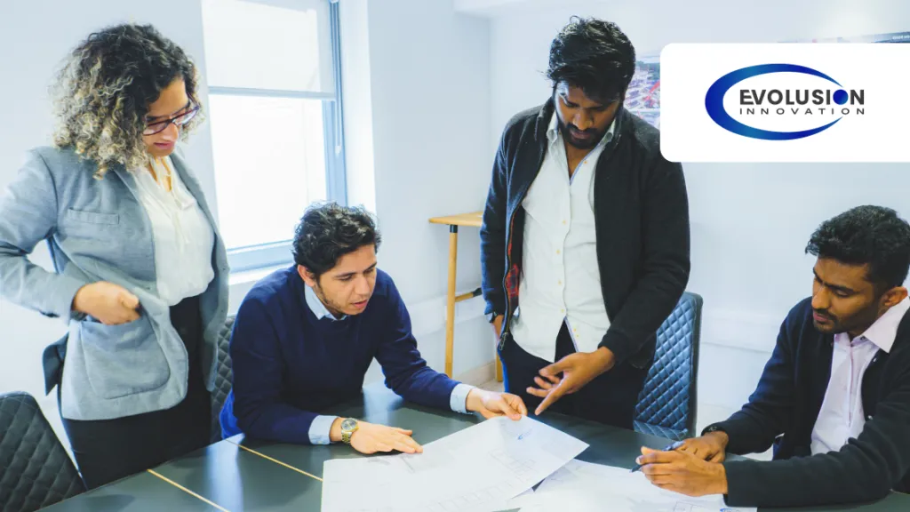 Four professionals collaborating around a desk reviewing documents in a bright office, with Evolution logo.