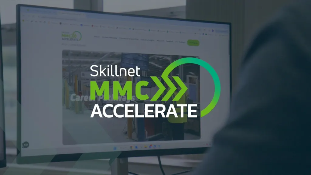 Person viewing a monitor displaying the Skillnet MMC Accelerate logo and program interface.