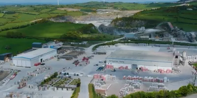 Aerial view of an industrial site with excavation areas surrounded by green countryside.