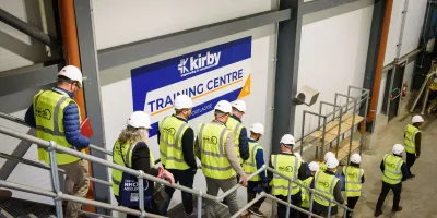 Group of workers in high-visibility vests touring the Kirby Training Centre facility.