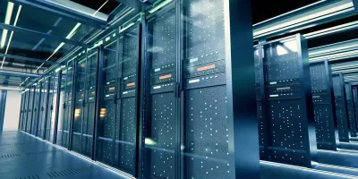 Modern data center with rows of illuminated server racks in a sleek, blue-lit corridor.