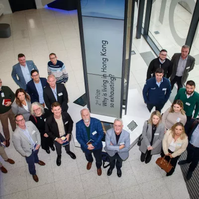 Group of people standing indoors, looking up towards the camera.