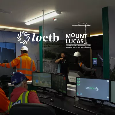 Four people in hard hats and high vis vets using computers in a room with computers and engineering equipment