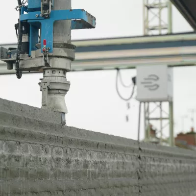 3D printing machine printing a new layer of a house wall.