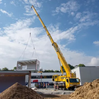 Modular housing unit being moved with a crane